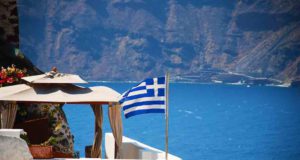 Wie viele Strophen hat die griechische Nationalhymne? Nationalhymne: Yacht mit griechischer Fahne vor Insel Santorin