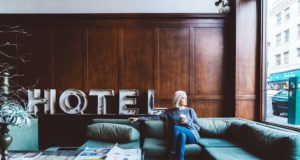 Was bringen Bonusprogramme der Hotels den Reisenden? Bonusprogramme: Frau sitzt im Hotel