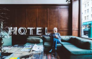 Was bringen Bonusprogramme der Hotels den Reisenden? Bonusprogramme: Frau sitzt im Hotel