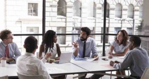 Travel Management: Raus aus dem Silo! Travel Management: Menschengruppe sitrzt am Tisch