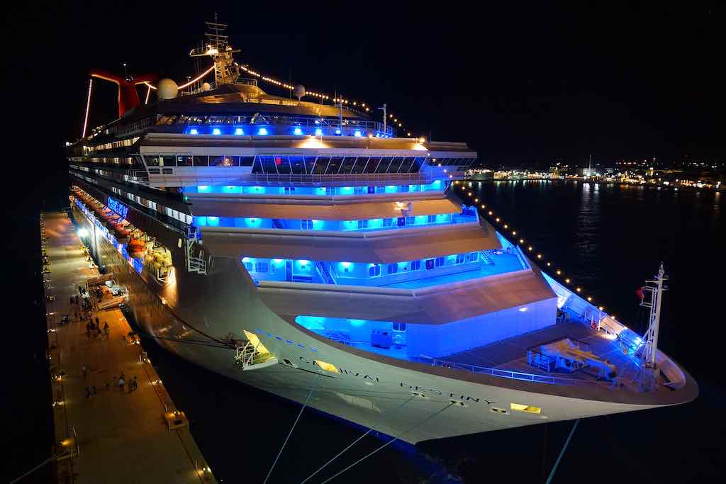 Kreuzfahrten: Im Hafen ein beleuchtetes Schiff am Abend