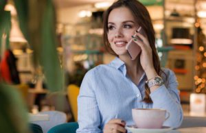 Maritim Hotels optimieren Internetauftritt Mritim Hotels: Frau telefoniert mit Smartphone in einem Lokal