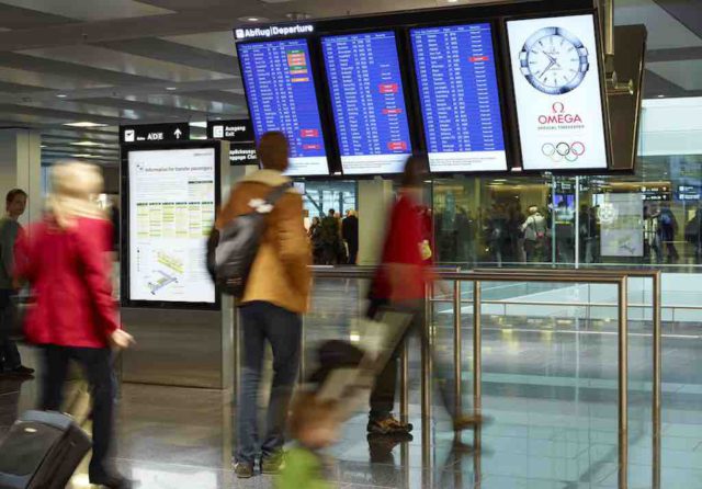 Flüge umbuchen: Menschen vor Hinweistafeln am Flughafen Zürich