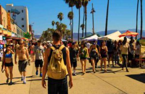 Wer sind Wachstumstreiber im Tourismus? Tourismus: Urlauber spazieren am Strand von Los Angeles