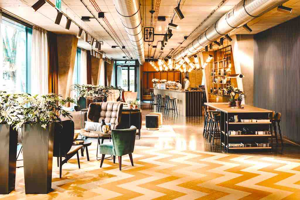 Neues Hotel Vienna House Mokotow: In der Lobby gibt es zwei Tische zum Arbeiten und für den Self-Check-in/-out sowie verschiedene Sitzbereiche (Foto: © Vienna House)