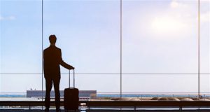 Richtiges Outfit für perfekte Geschäftsreisen g: wartet mit Koffer auf seinen FluhDie Geschäftsreisen in Österreich sind wieder im Kommen.