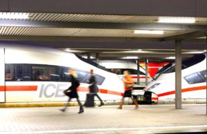 ICE-Züge starten in die Urlaubsregionen Mit dem Zug statt mit dem Flugzeuge: Reisende gehen am Bahnsteig vorbei an zwei geparkten ICE-Zügen