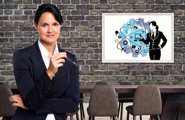 Travel Manager ist ein gefragtes Beruf: Bild zeigt eine Managerin mit Brille in der Hand in ihrem Büro, an dessen Wand ein Bild hängt
