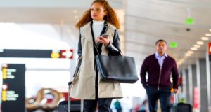 Stresslevel auf Geschäftsreisen geht zurück Fürsorgepflicht & Geschäftsreise: Eine Frau mit einem Koffer auf dem Weg zum Flugsteig am Airport