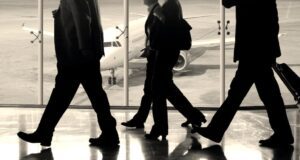 Business Travel: Neues Kostenbewusstsein Business Travel: Passagiere auf einem Flughafen, im Hintergrund ist ein Jet zu sehen