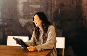 Karriere in der Tourismusbranche machen Karriere: Junge Frau sitzt vor Laptop und sucht Job im Internet