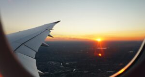 Der Flugverkehr und die nachhaltige Zukunft Flugverkehr: Blick aus dem Flugzeug auf en Sonnenuntergang