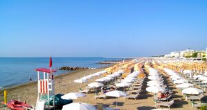 Venetien und seine schönsten Sandstrände Venetien: Bild zeigt einen kilometerlangen Sandstrand mit Liegestühlen und Sonnenschirmen in Venetien
