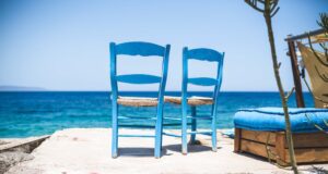 Reisekataloge und die geschönte Wahrheit Reisekataloge versprechen oft das Blaue vom Himmel: Zwei Stühle und Blick aufs Meer