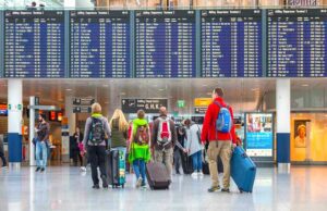 Evaneos bietet keine Kurzreisen mehr an Evaneos beendet Angebot mit Kurzreisen: Bild zeigt Reisende mit Gepäck vor der Abflugtafel auf dem Flughafen München beim Einchecken