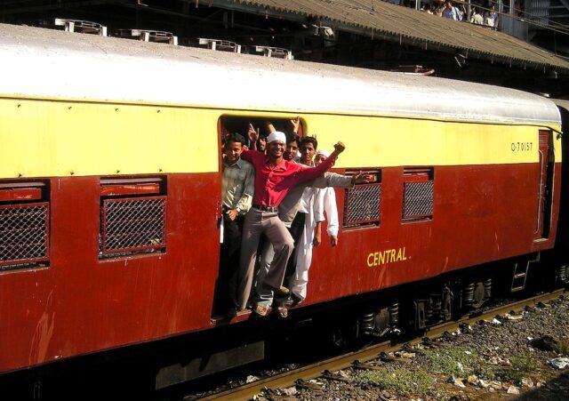 Inder sind die neuen Reiseweltmeister. lieben das Reisen: Bild zeigt einen Zug in Indien mit Menschengruppe bei der Wagontüre