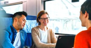 BahnBonus mit Vorteil für Business People BahnBonus der Deutschen Bahn mit Vorteil für Business People. Bild zeigt eine Frau am Laptop mit zwei männlichen Reisenden in einem Zugabteil der Deutschen Bahn