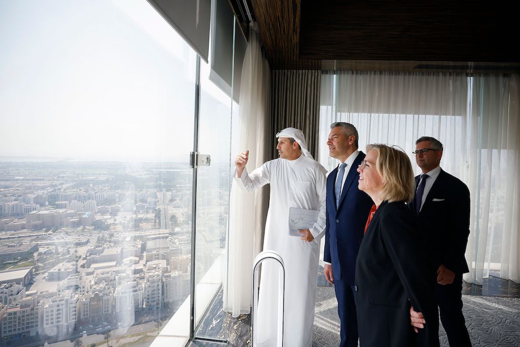 Business Aviation und der Klimawandel: Bild zeigt Kanzler Nehammer und Klimaministerin Gewesner in Abu Dhabi, wo sie aus einem Hochhaus auf das Emirat herabsehen