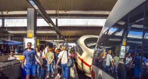 Mit RailEurope statt mit Flugzeug verreisen Reisen mit RailEurope: Dichtes Gedränge von Reisenden am Bahnsteig zwischen zwei stehenden Zügen