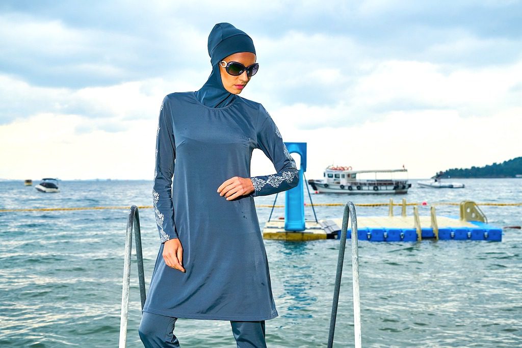 Mode für Muslimas: Frau in einem Kleid mit Kopftuch an einem Strand