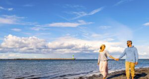 Ostsee Guide App mit noch mehr Meer-Wert Ostsee Guide mit Meer-Wert: Junges Paar spaziert in Travemünde am Strand