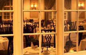 Michelin, Falstaff, Gault-Millau und der Futterneid Guide MIchelin: Blick durch ein Fenster in das Innere eines eleganten Restaurants