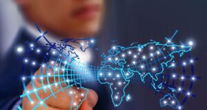 Künstliche Intelligenz im Travel Management Künstliche Intelligenz: Bild zeigt eine digitalisierte Weltkarte, ein Mann zeigt mit Finger auf einen der vielen Lichtpunkte in der Karte