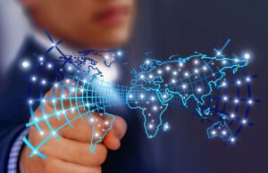 Künstliche Intelligenz im Travel Management Künstliche Intelligenz: Bild zeigt eine digitalisierte Weltkarte, ein Mann zeigt mit Finger auf einen der vielen Lichtpunkte in der Karte