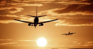 Wie gehen Airlines mit Beschwerden um? Welche Airlines zuverlässig sin d und welche weniger: Zwei Flugzeuge fliegen im Sonnenuntergang am Himmel