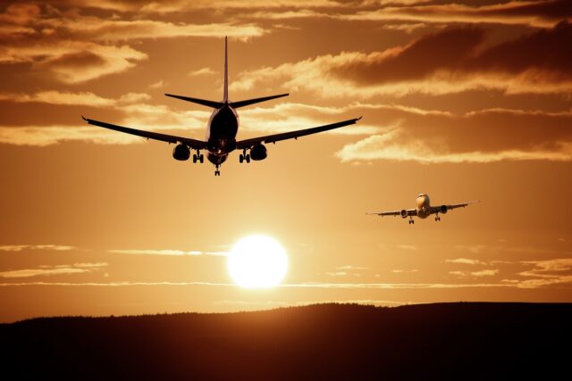 Welche Airlines zuverlässig sin d und welche weniger: Zwei Flugzeuge fliegen im Sonnenuntergang am Himmel