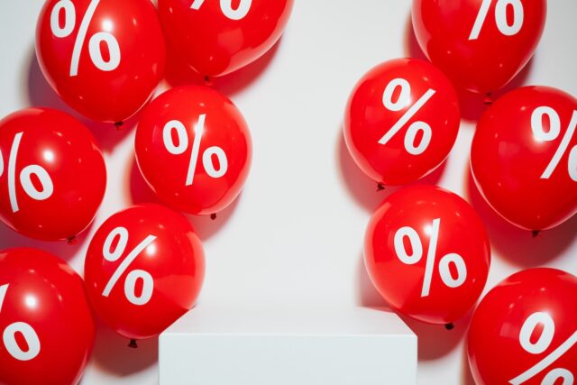 Rote Luftballons mit dem Prozentsymbol symbolisieren Rabatte und Boni