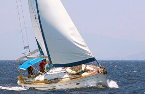 Reise-Community für Aktive: Feel The Spirit! Segeln mit der Reise-Community. Segelboot in voller Fahrt, etwas seitlich geneigt, der Wind von rechts bläht das Vordersegel auf