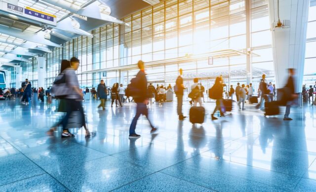Flexible Geschäftsreisen Flexible Geschäftsreisen Menschen mit Gepäck eilen in einer Halle auf einem Flughafen in Richtung Abfertigungshalle