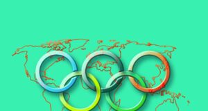 Risk Map für die Olympischen Spiele in Paris Risk Map warnt vor Risikoquellen während der Olympischen Spiele in Paris: Fünf ineinander verkettete olympische Ringe im Vordergrund einer grünen Weltkarte