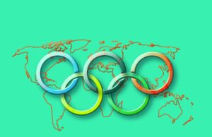 Risk Map für die Olympischen Spiele in Paris Risk Map warnt vor Risikoquellen während der Olympischen Spiele in Paris: Fünf ineinander verkettete olympische Ringe im Vordergrund einer grünen Weltkarte