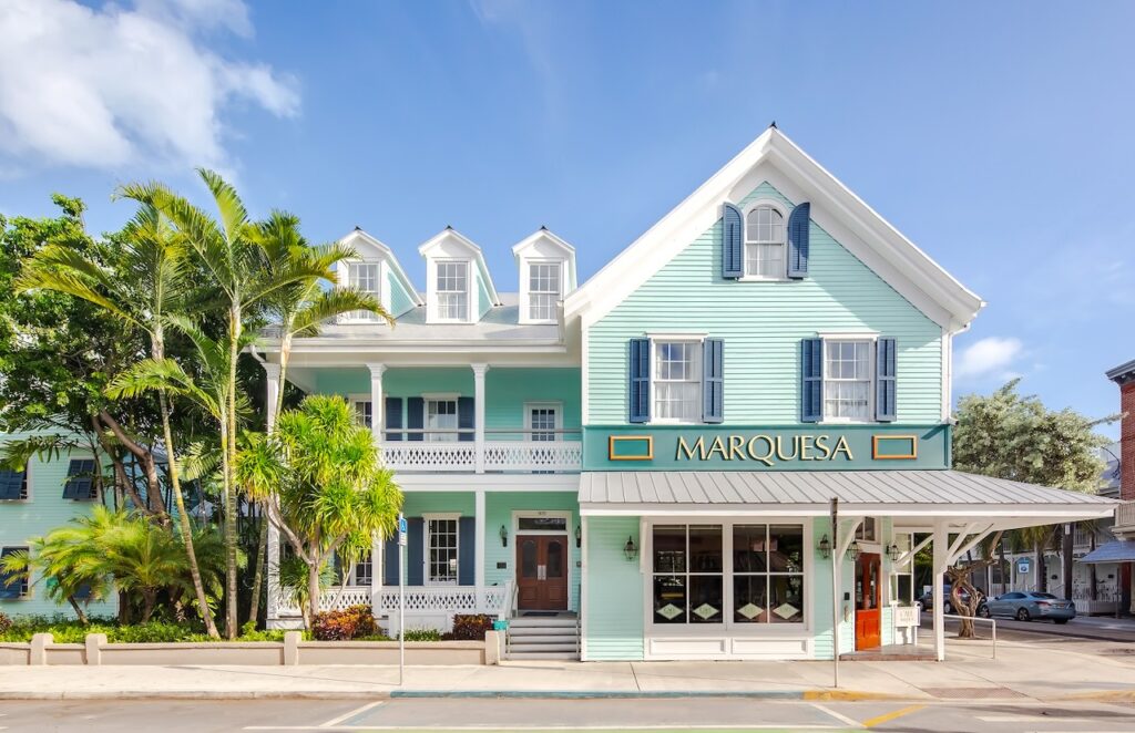 Weiß-grün getünchtes Hotel Marquesa in Key West mit Palmengruppe