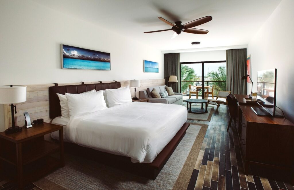 Luxuriöses Hotelzimmer mit großem Bett, Sotzgarnitur und Ausblick auf Palmen im Perry Hotel und Marina auf Stock Island auf den Florida Keys