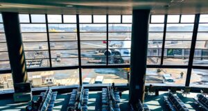 Luftverkehrsteuer in Schweden abgeschafft Leerer Wartesaal in einem Flughafen mit Blick aufs Vorfeld, wo ein Flugzeug fürs Boarding bereit ist