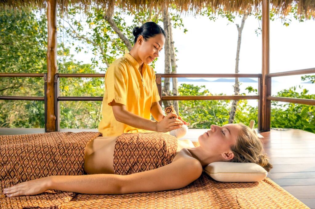 Eine Frau bei einer Massage in einem tropischen Ambiente