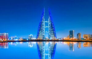 In Bahrain die Perlenkultur entdecken Die Skyline von Bahrain Stadt mit Relfektierung im Wasser
