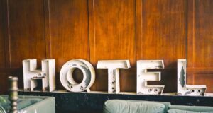 Hotelbranche fürchtet noch höhere Kosten Symbol für Hotelbranche: Buchstaben, die das Wort Hotel bilden, lehnen an einer braunen Holzwand