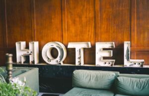 Hotelbranche fürchtet noch höhere Kosten Symbol für Hotelbranche: Buchstaben, die das Wort Hotel bilden, lehnen an einer braunen Holzwand