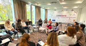 Tagungshotels: Begegnungen sind Trumpf! Diskussion über Tagungshotels: Gruppe von Frauen und Männer sitzen in einem hellen Raum mit einer beschrifteten Tafel im Hintergrund