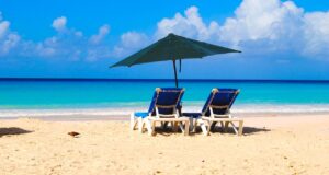 Barbados: Inselglück im Herzen der Karibik Gelber Sandstrand mit zwei Liegestühlen und einen Sonnenschirm, am Horizont das Türkise Meer und einige weiße Wolken: Das ist Barbados, die Sonneninsel in der Karibik