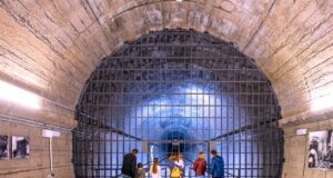 Regierungsbunker als Touristen-Attraktion Unterwegs im Regierungsbunker: Eine Menschengruppe steht in einem Tunnel vor einem Gitter und blickt in den bläulichen Hintergrund