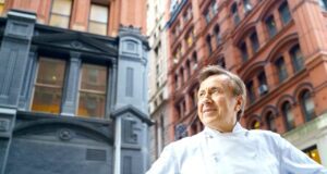 Sternekoch bekocht USA-Flugpassagiere Mann in weißer Bekleidung steht auf der Straße und blickt auf die Häuser rund um ihn. Exklusiv für Air France-Fluggäste präsentiert Sternekoch Daniel Boulud Gerichte mit rotem Fleisch und Geflügel (Bild: Eric Vitale Photography)