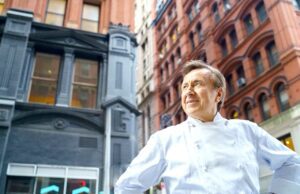 Sternekoch bekocht USA-Flugpassagiere Mann in weißer Bekleidung steht auf der Straße und blickt auf die Häuser rund um ihn. Exklusiv für Air France-Fluggäste präsentiert Sternekoch Daniel Boulud Gerichte mit rotem Fleisch und Geflügel (Bild: Eric Vitale Photography)