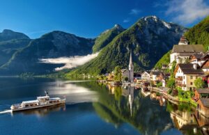 Österreichs Tourismus im Focus der Politik Ein Touristenschiff auf dem grünblauen Hallstätter See vor Hallstatt