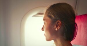 Wird Check-in auf Flugreisen überflüssig? selektives-fokusfoto-der-frau-die-auf-stuhl-sitzt-und-ausserhalb-des-fensters-auf-flugzeug-schaut-