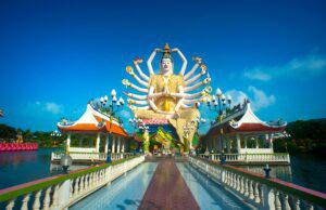 Flugbuchungen zeigen neuen Asien-Boom Spinnenartige Figur vor einem buddhistischen Tempel in Thailand